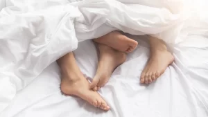 couples feet under the blanket